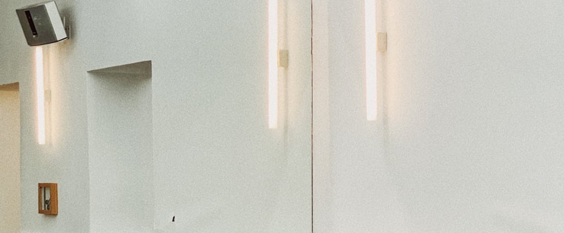 Linear warm lighting integrated into a pale architectural interior